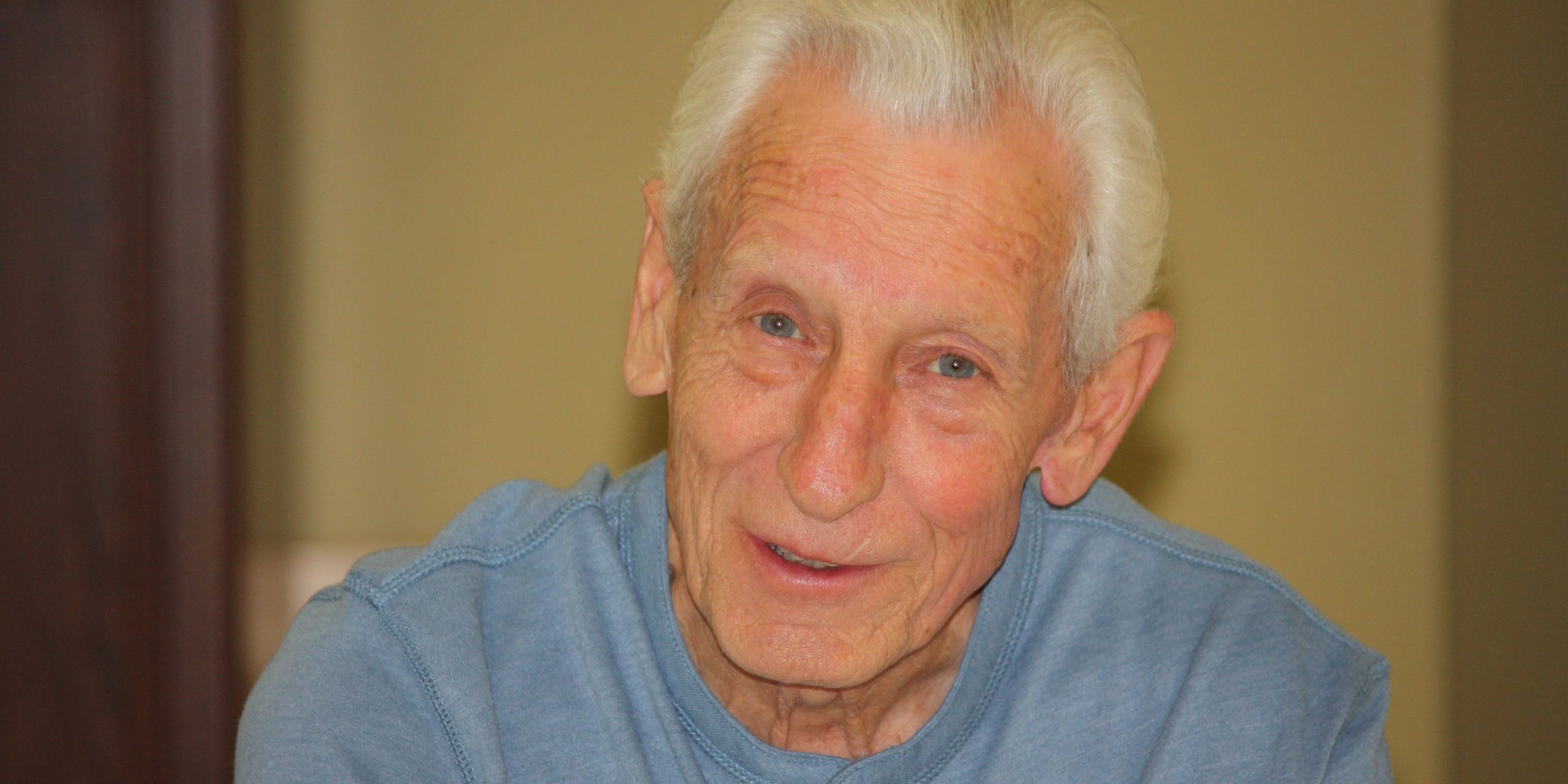 radio: an older gentleman wearing a light blue henley