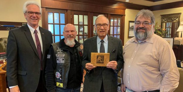 Rolling Thunder: four men smiling at the camera holding a plaque