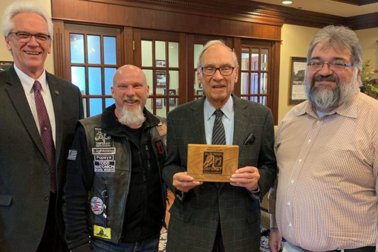 Rolling Thunder: four men smiling at the camera holding a plaque