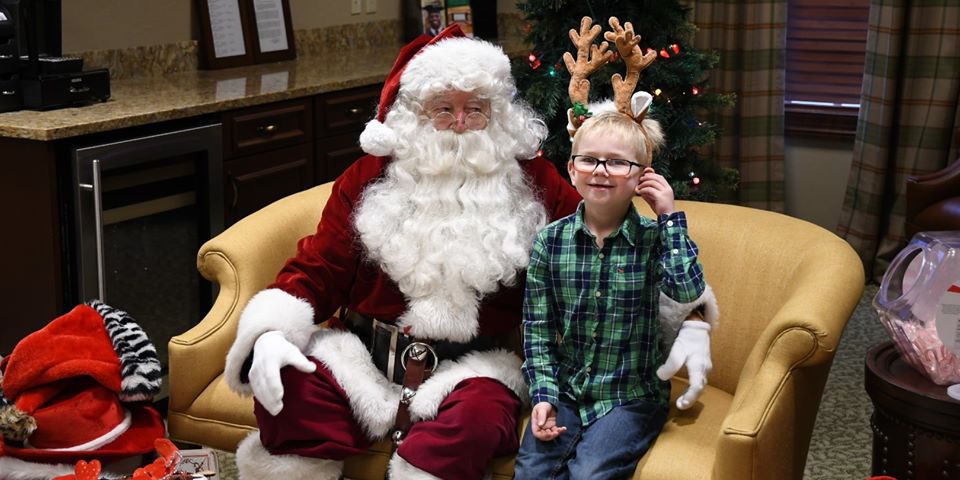Pancakes with Santa santa sitting with a young boy wearing antlers